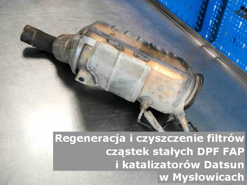 Wypalony z sadzy katalizator samochodowy marki Datsun, w pracowni regeneracji na stole, w Mysłowicach.